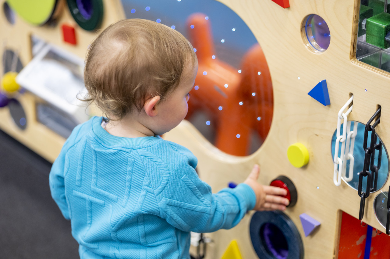 a small child plays with the sensory wall at Tarneit library