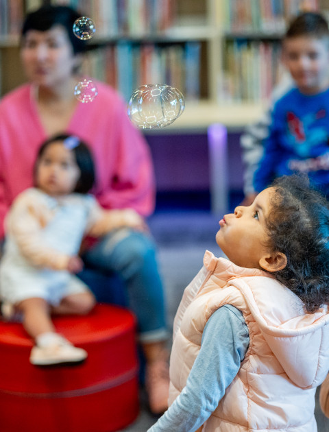 Small children with bubbles in the library