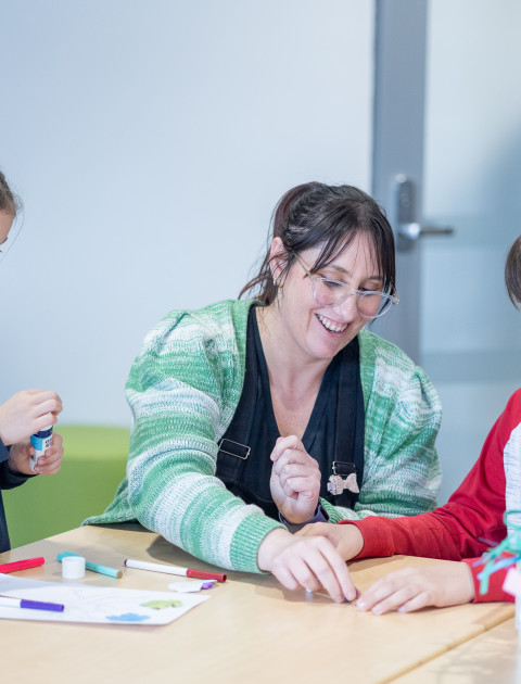 2 children and an adult completing a craft activity at the library.