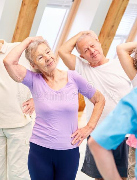 a group of older people are standing with their hand on their head pulling it to the side