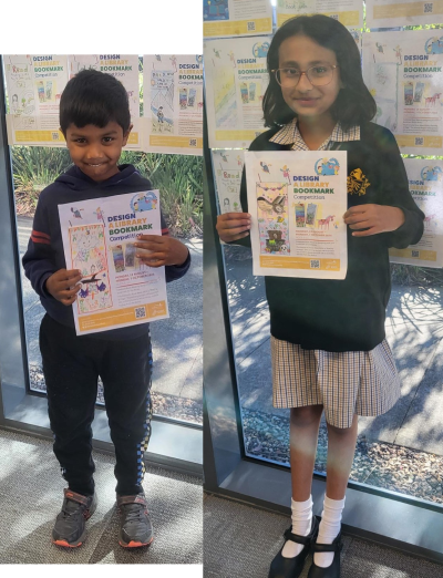 the two winners of the bookmark competition, holding their entries