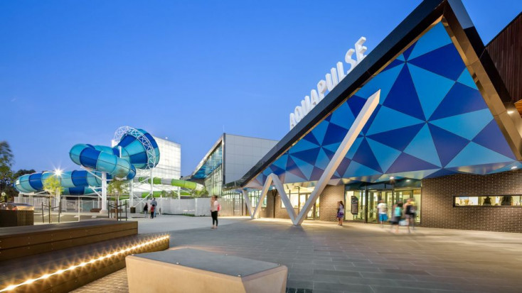 a blue building with an enclosed blue slide beside it that twists around 360 degrees 