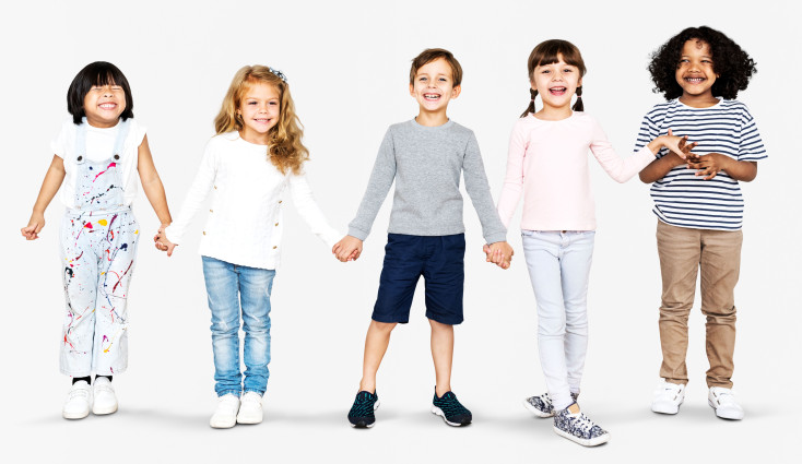 five children are holding hands and looking at the camera