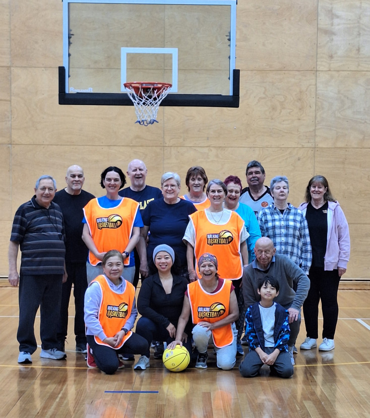 a group of men and women of all ages are smiling at the camera