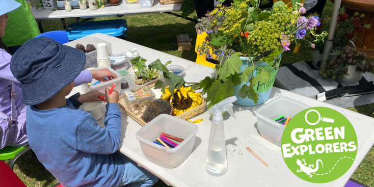 Children planting seeds at a table with sunflowers on the table. 