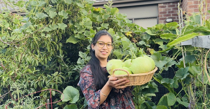 Sunita in her food garden holding her produce