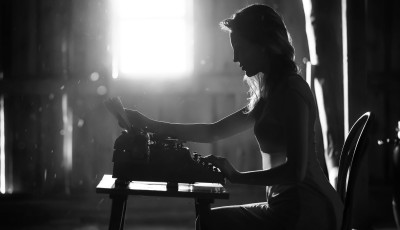 black and white image of someone at a typewriter