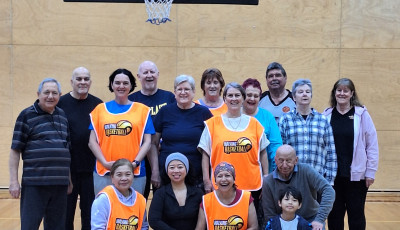 a group of men and women of all ages are smiling at the camera