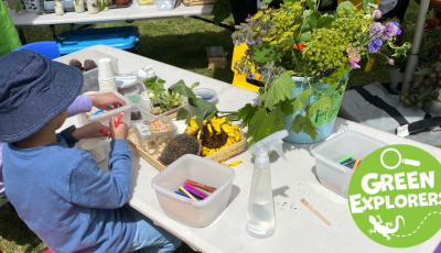 Children planting seeds at a table with sunflowers on the table. 