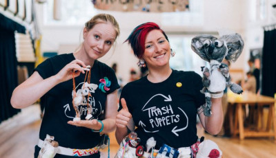 Person holding up puppets made from recyclable items