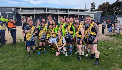 a group wearing yellow sports tops are smiling at the camera