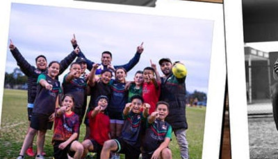 a group of boys and girls in sports uniforms are cheering at the camera