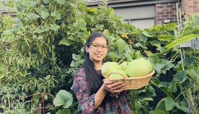 Sunita in her food garden holding her produce