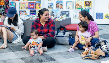 Parents and children sitting together in the library.