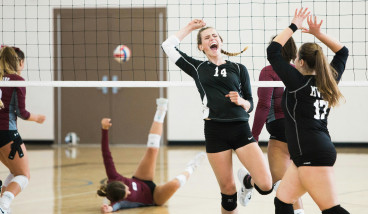 girls in black sports kit are playing volleyball