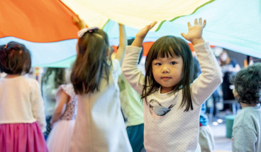 Children at Rhyme Time playing with a parachute